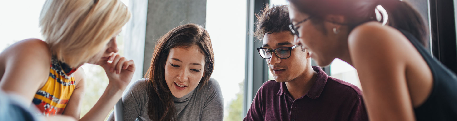 A group of four students sitting at a table working on a project