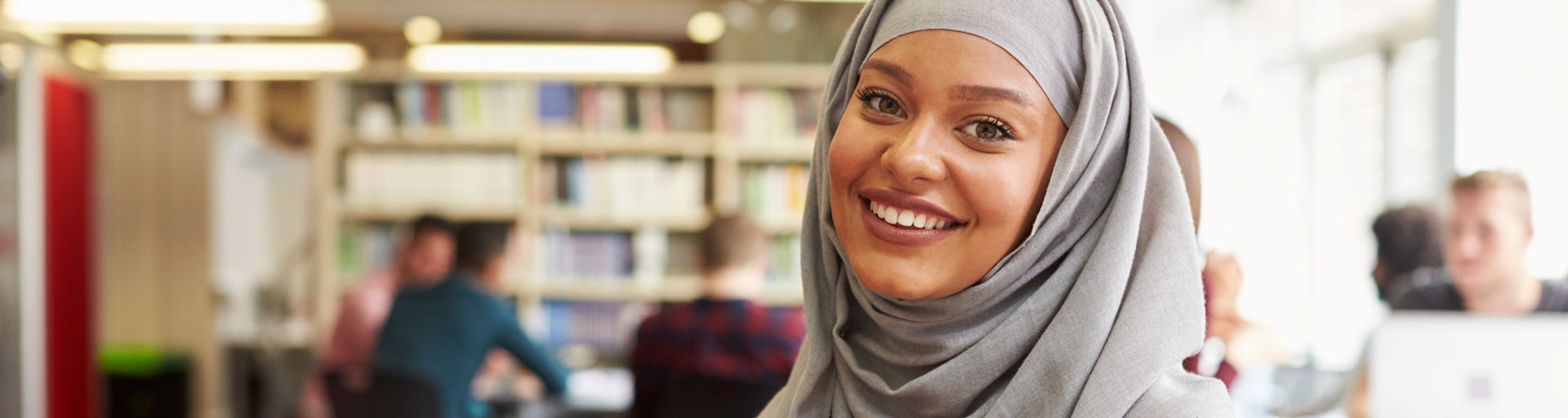 smiling student wearing a grey hijab